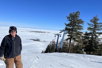 caption: General Manager Steve Hickman stands at the top of Badger Mountain Ski Area with Waterville, Washington, visible in the distance.