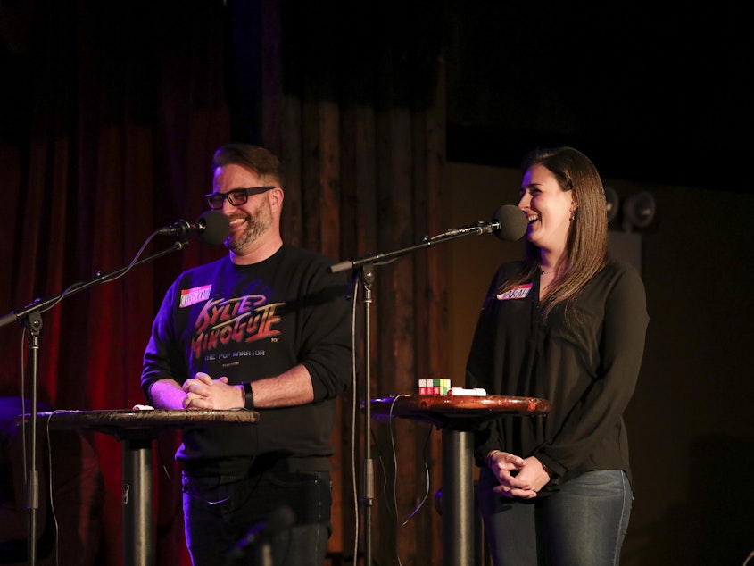 caption: Contestants face off in the final round on Ask Me Another at the Bell House in Brooklyn, New York.