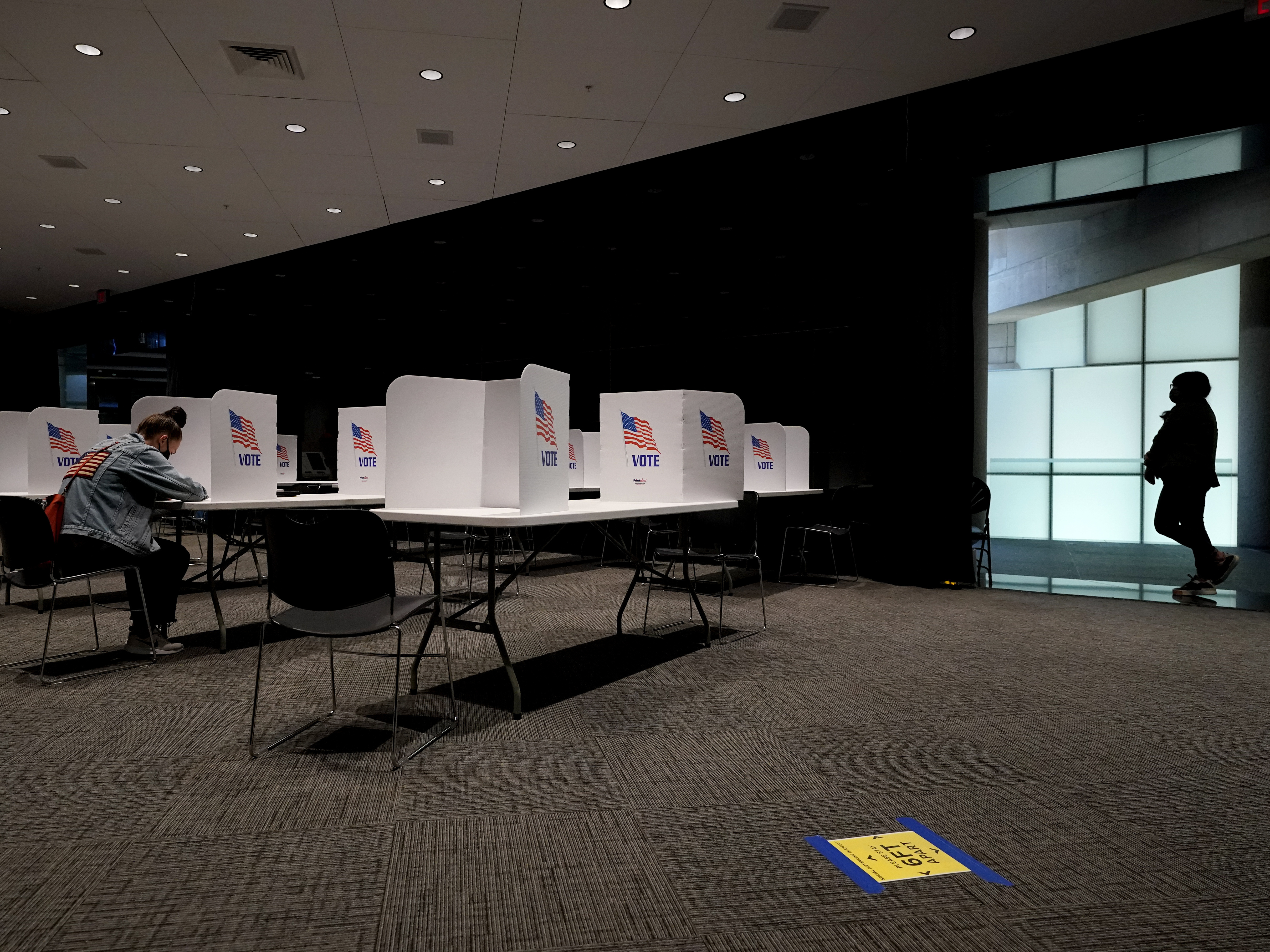 caption: A poll worker (right) waits while a woman votes Tuesday at the National World War I Museum & Memorial in Kansas City, Mo.
