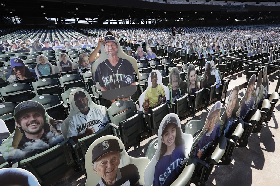 caption: A Seattle Mariners worker places a fan cutout in a seat at the team's ballpark as part of the "Mariners Seat Fleet" in place of real fans, Monday, July 27, 2020, in Seattle. The Mariners open play at home against the Oakland Athletics on Friday.