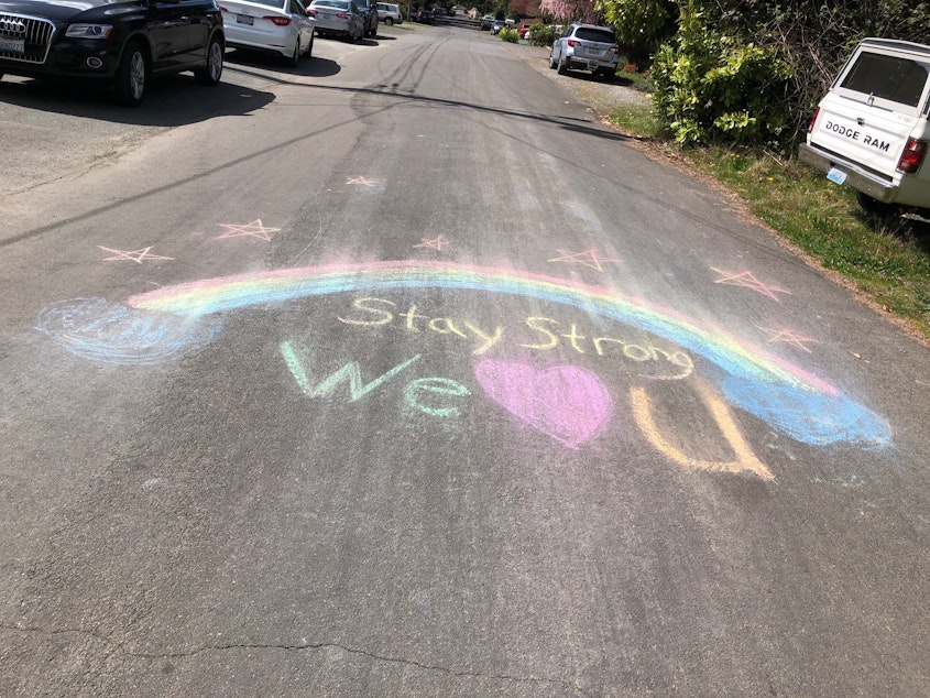 caption: Children leave an artistic message in chalk on a North Seattle street. 