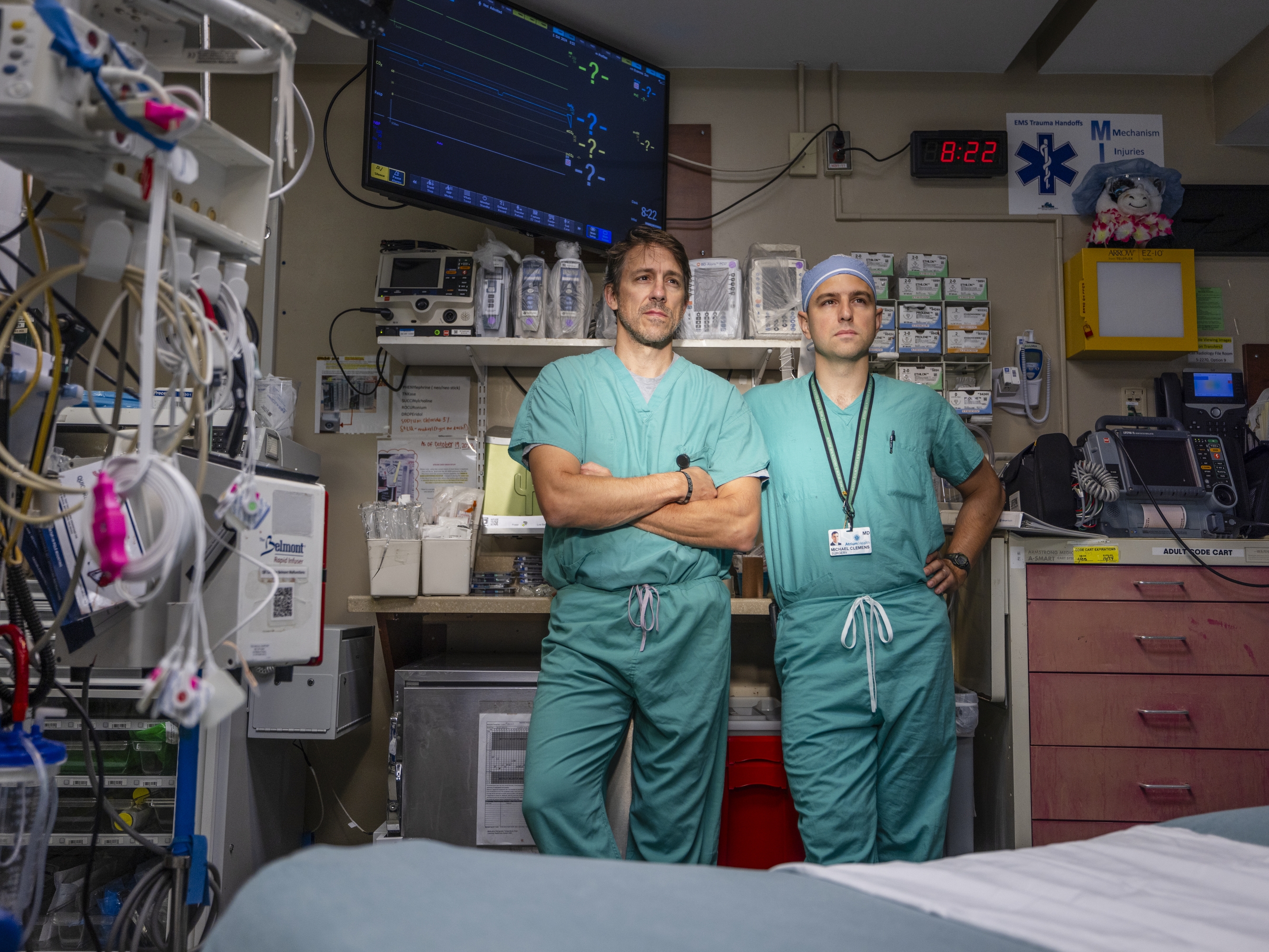 caption: Dr. David Callaway (left) and Dr. Michael Clemens (right) pose for a photo inside one of the trauma bays inside the emergency department at the main Atrium Health campus in Charlotte, N.C. on Oct. 1. The hospital is currently part of a civilian/ military partnership combining medial care in the emergency department.