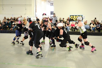 caption: Brutal Poodles jammer Carmen Getsome pushes her way through the pack during Rat City Roller Derby's 20th Anniversary alumni exhibition.