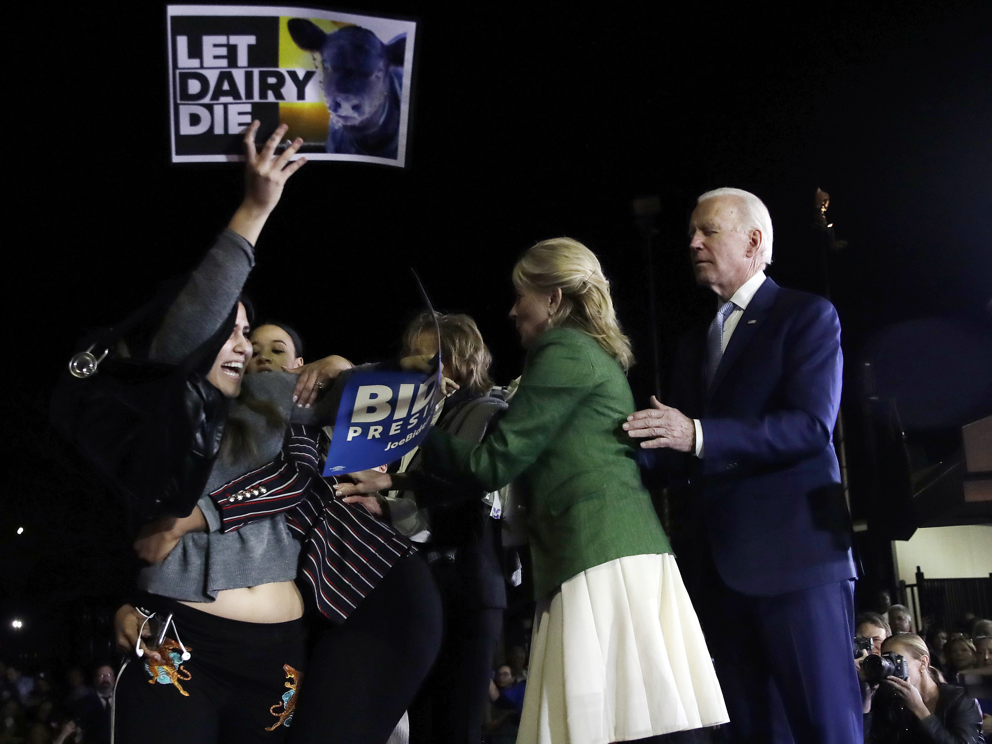 caption: Jill Biden and staffer hold back protester at Joe Biden's Super Tuesday rally in Los Angeles.
