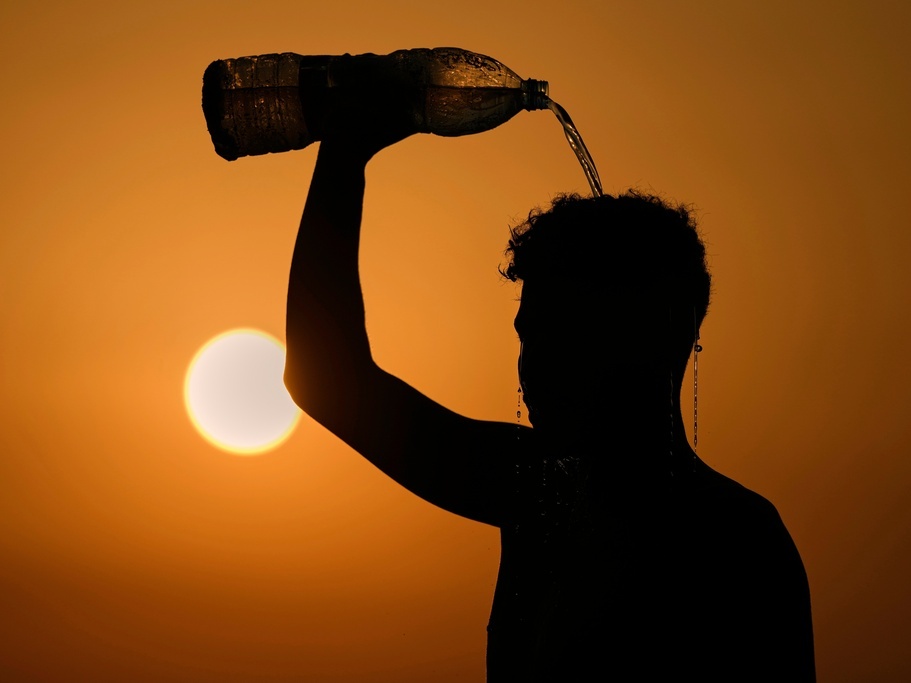caption: A man rinses with water in August after playing beach footvolley on the Ramlet al-Baida public beach in Beirut, Lebanon,, on a sweltering hot day.