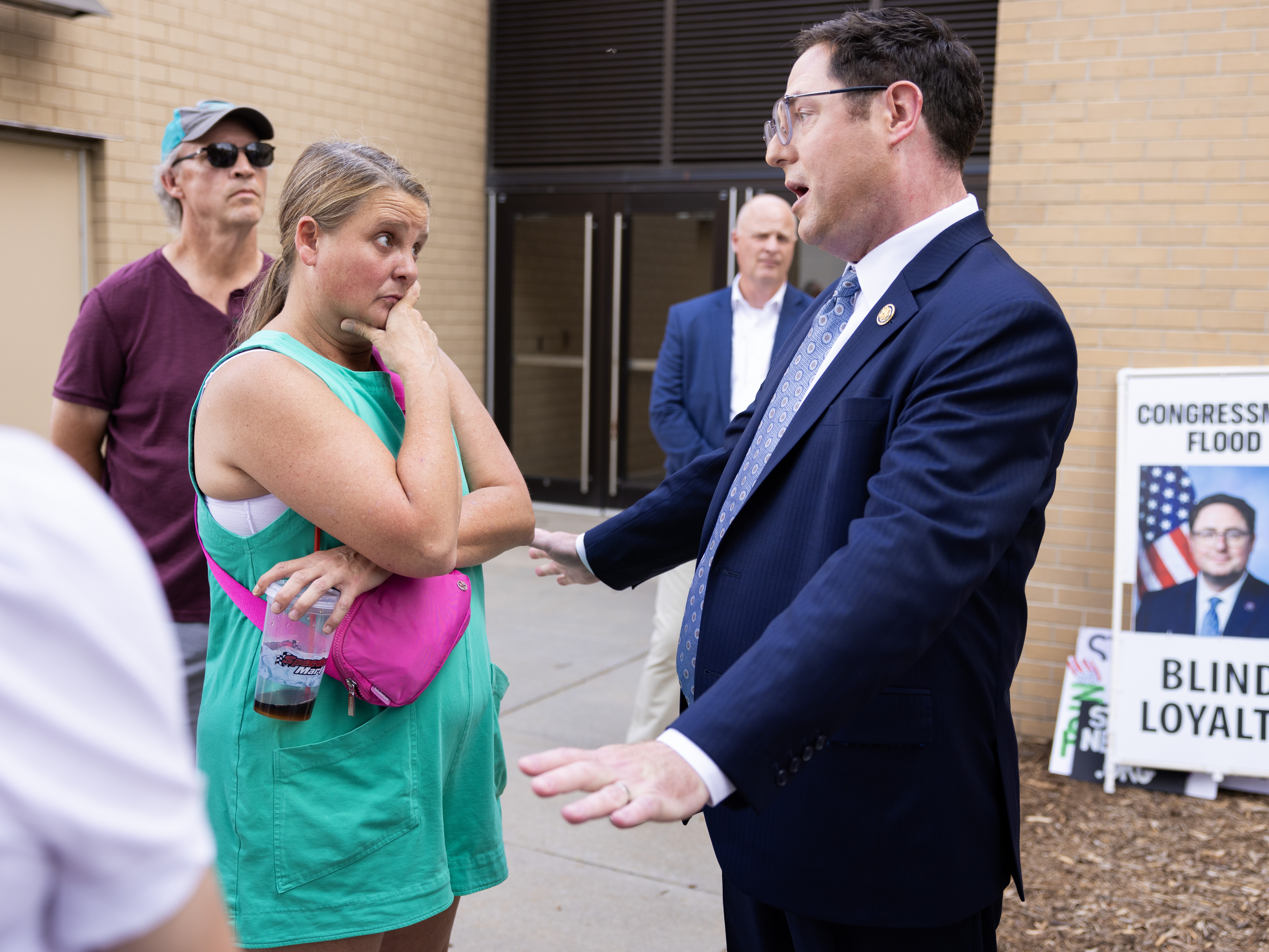 caption: Karen Wagner speaks with Rep. Mike Flood before a town hall at Kimball Recital Hall on the campus of the University of Nebraska-Lincoln in Lincoln, Neb., on Aug. 4.