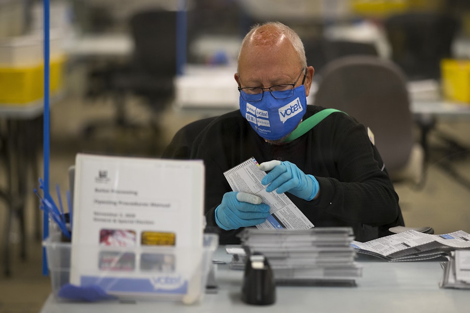 caption: An elections worker removes ballots from envelopes on Wednesday, October 28, 2020, at King County Elections in Renton.