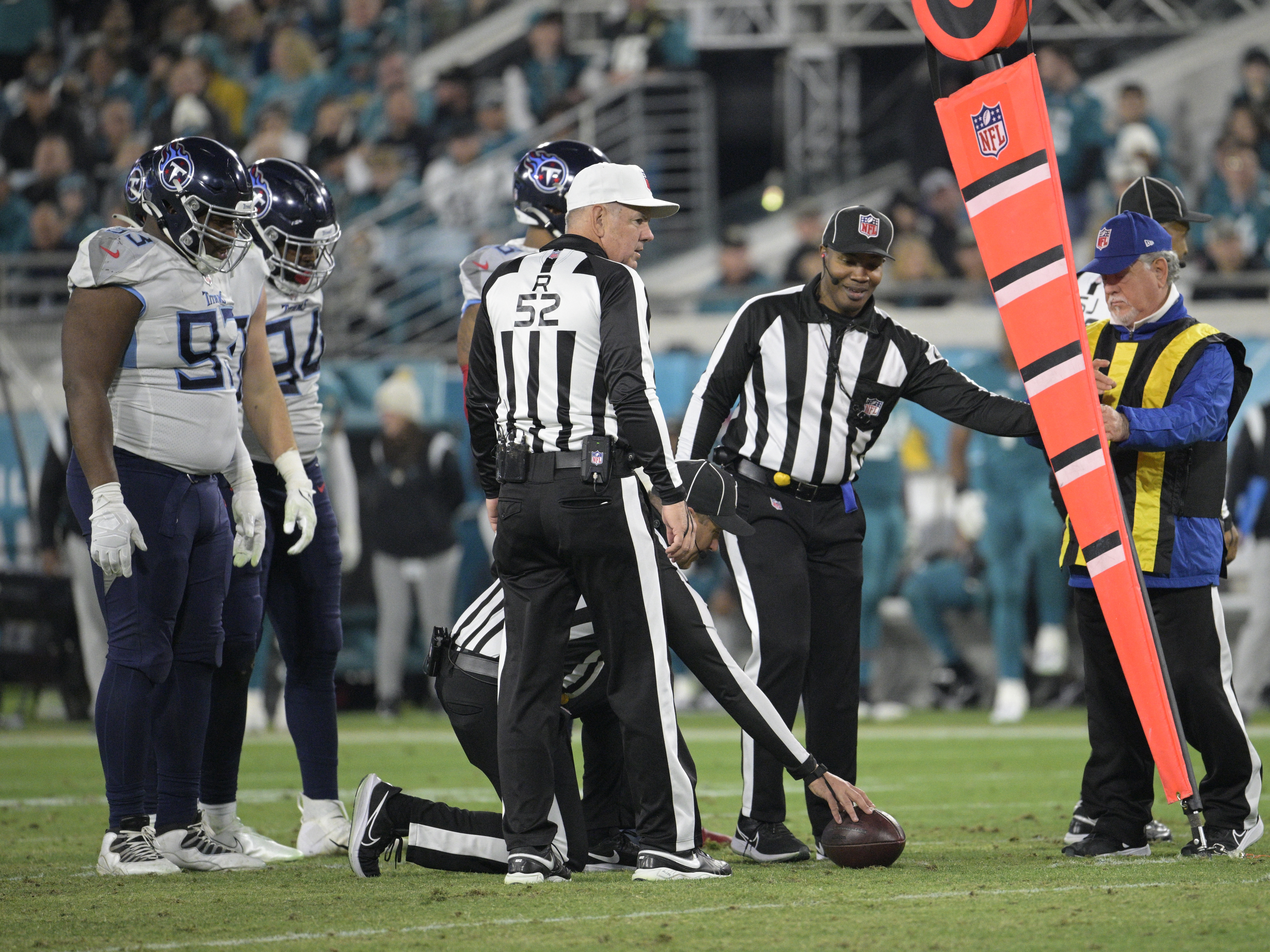 caption: Referee Bill Vinovich (52) watches as the officiating crew takes a measurement during the second half of an NFL football game between the Jacksonville Jaguars and the Tennessee Titans in 2023. Starting next season, the NFL will move to a camera system to determine if a first down has been reached.