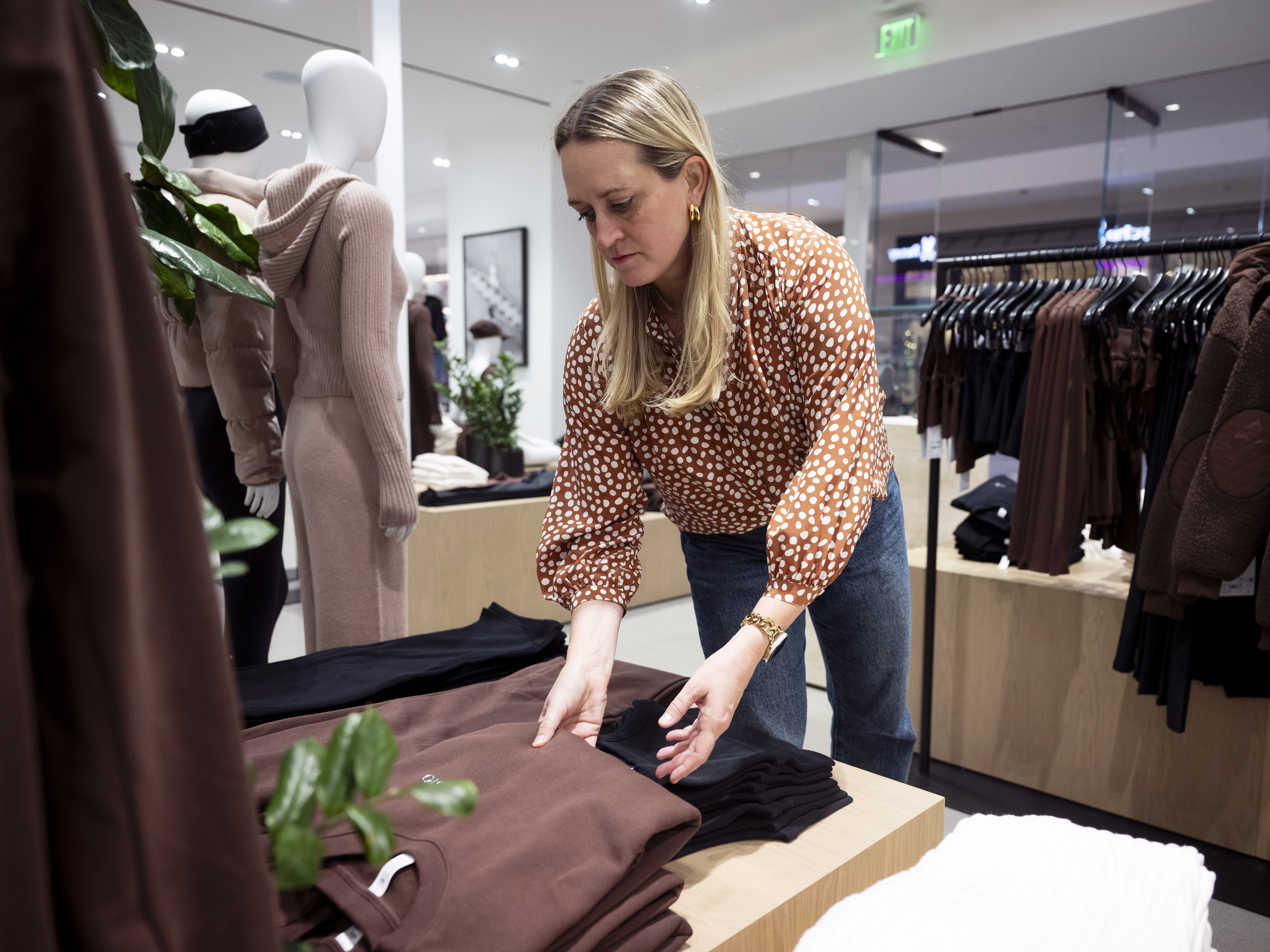 caption: Retail expert Katie Thomas looks through clothing at a store inside Pittsburgh's Ross Park Mall. She leads the Kearney Consumer Institute, a think tank inside a consulting firm used by some of the biggest retailers and brands