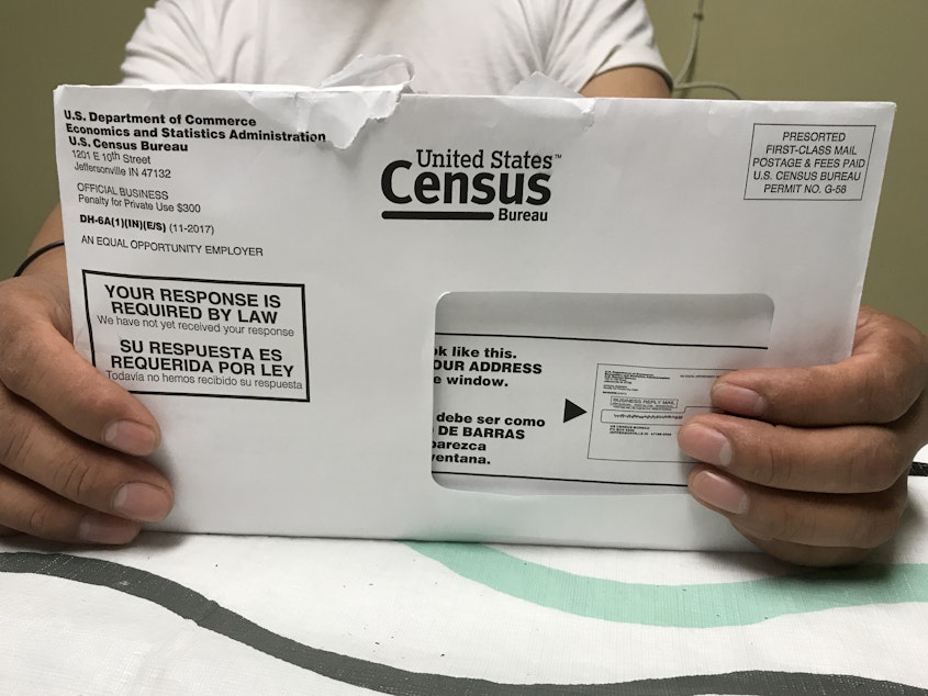 caption: A Rhode Island resident holds an envelope he received for the 2020 census test run in Providence County.