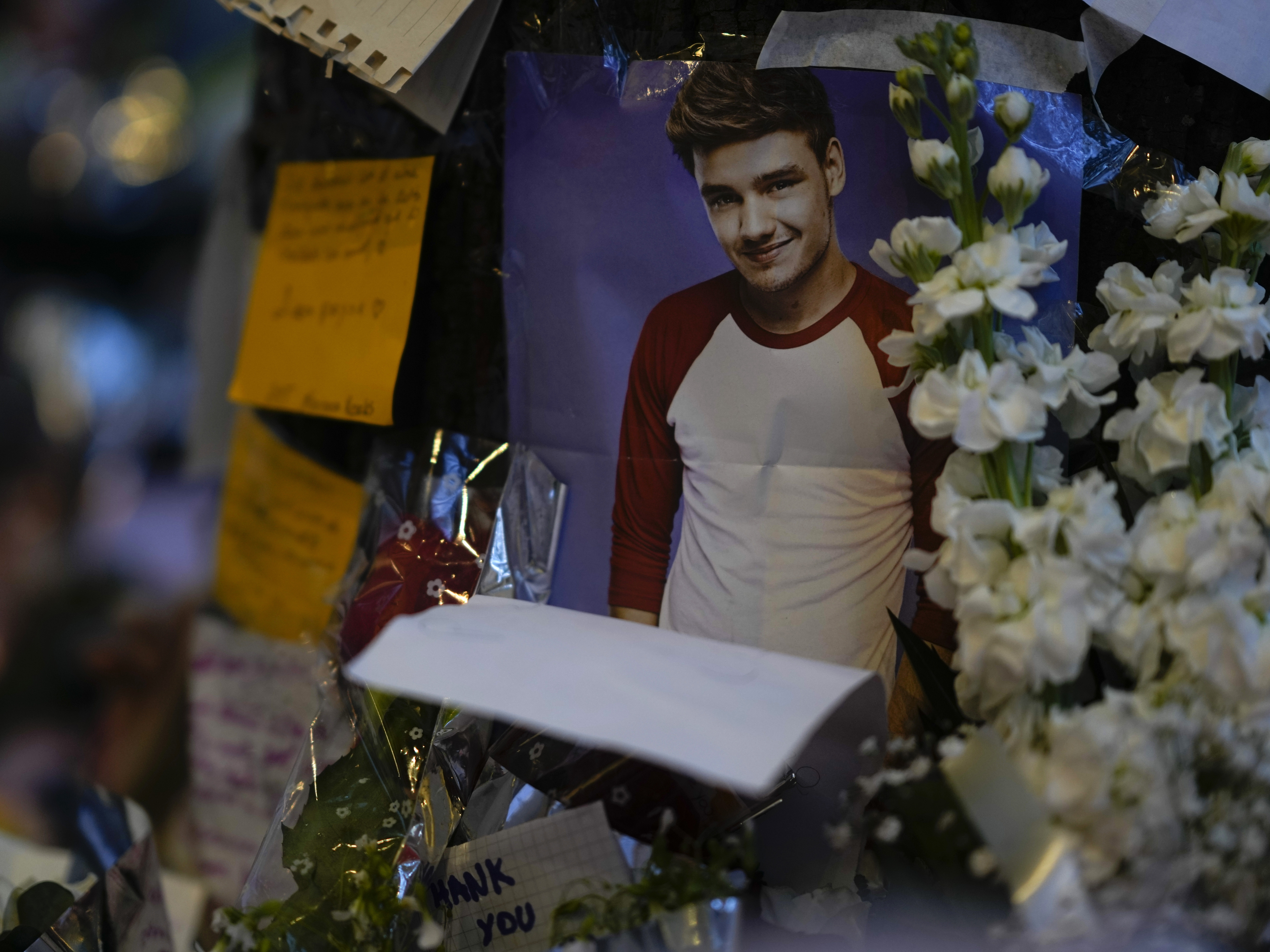 caption: A picture of former One Direction singer Liam Payne adorns a memorial outside the hotel where he was found dead after falling from a balcony in Buenos Aires, Argentina, Thursday, Oct. 17, 2024.