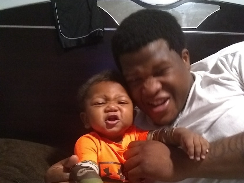 caption: Jemel Roberson and his 9-month-old son.