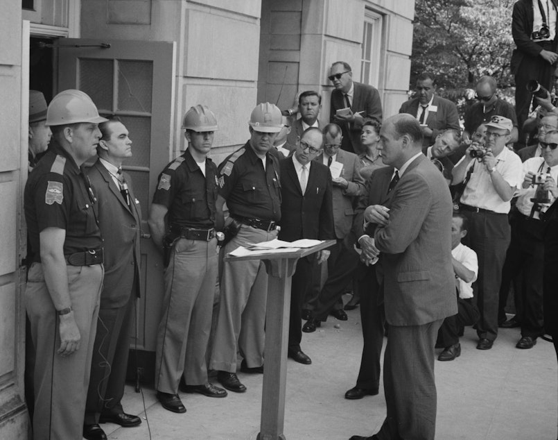 caption: Gov. George Wallace, left, attempts to block integration at the University of Alabama on June 11, 1963.