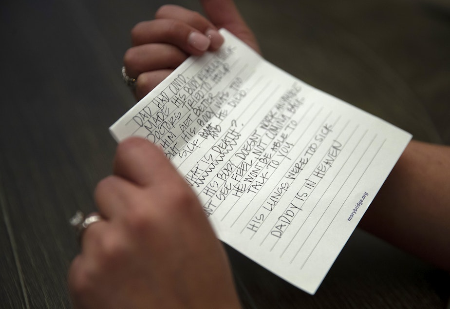caption: Christy Maricle holds a letter that she wrote to her children after her husband, Kurt Mrsny, died of Covid in September of last year, at their home on Thursday, December 9, 2022, in Puyallup. 