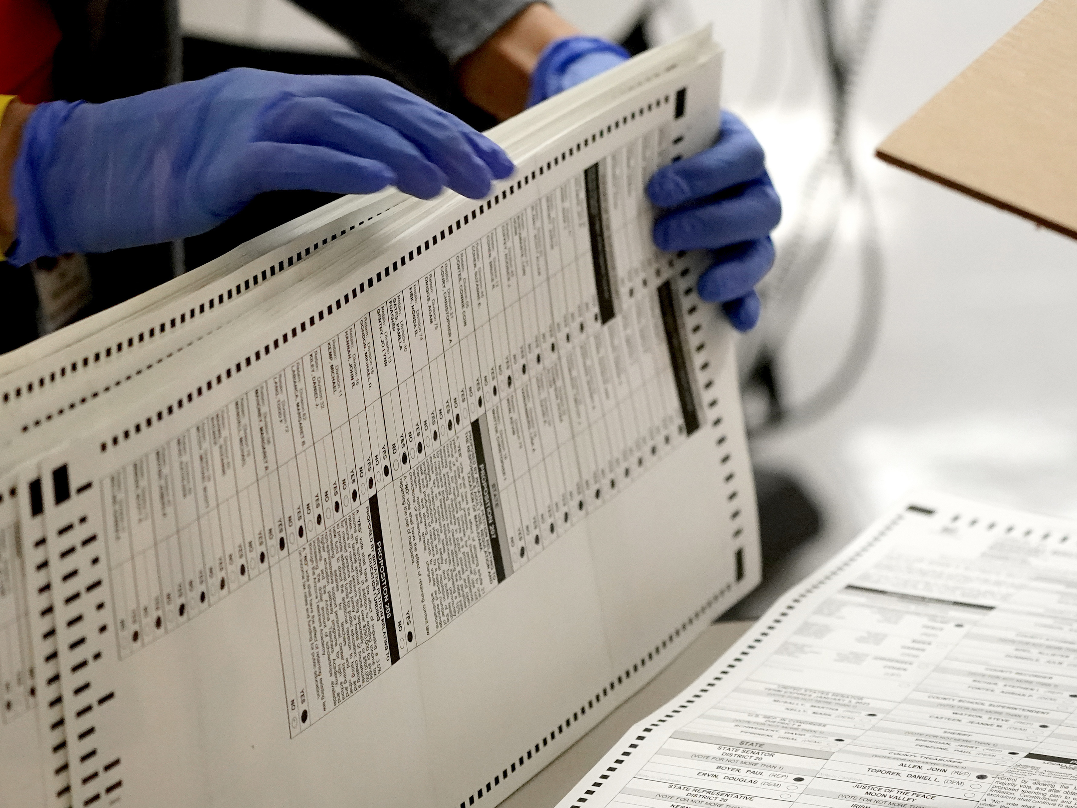 caption: Maricopa County, Ariz., elections officials count ballots on Nov. 4, 2020, at the Maricopa County Recorder's Office in Phoenix. Eight years after carving the heart out of a landmark voting rights law, the Supreme Court put new limits on efforts to combat racial discrimination in voting.