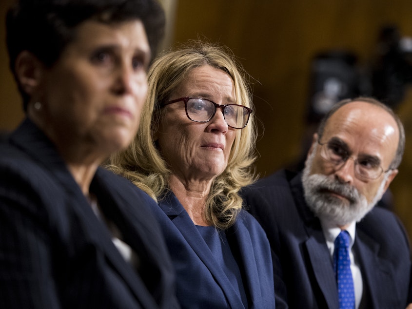 caption: Christine Blasey Ford, center, flanked by attorneys Debra Katz, left, and Michael Bromwich. The attorneys say that although Ford has tried to return to her life, she endures harassment.