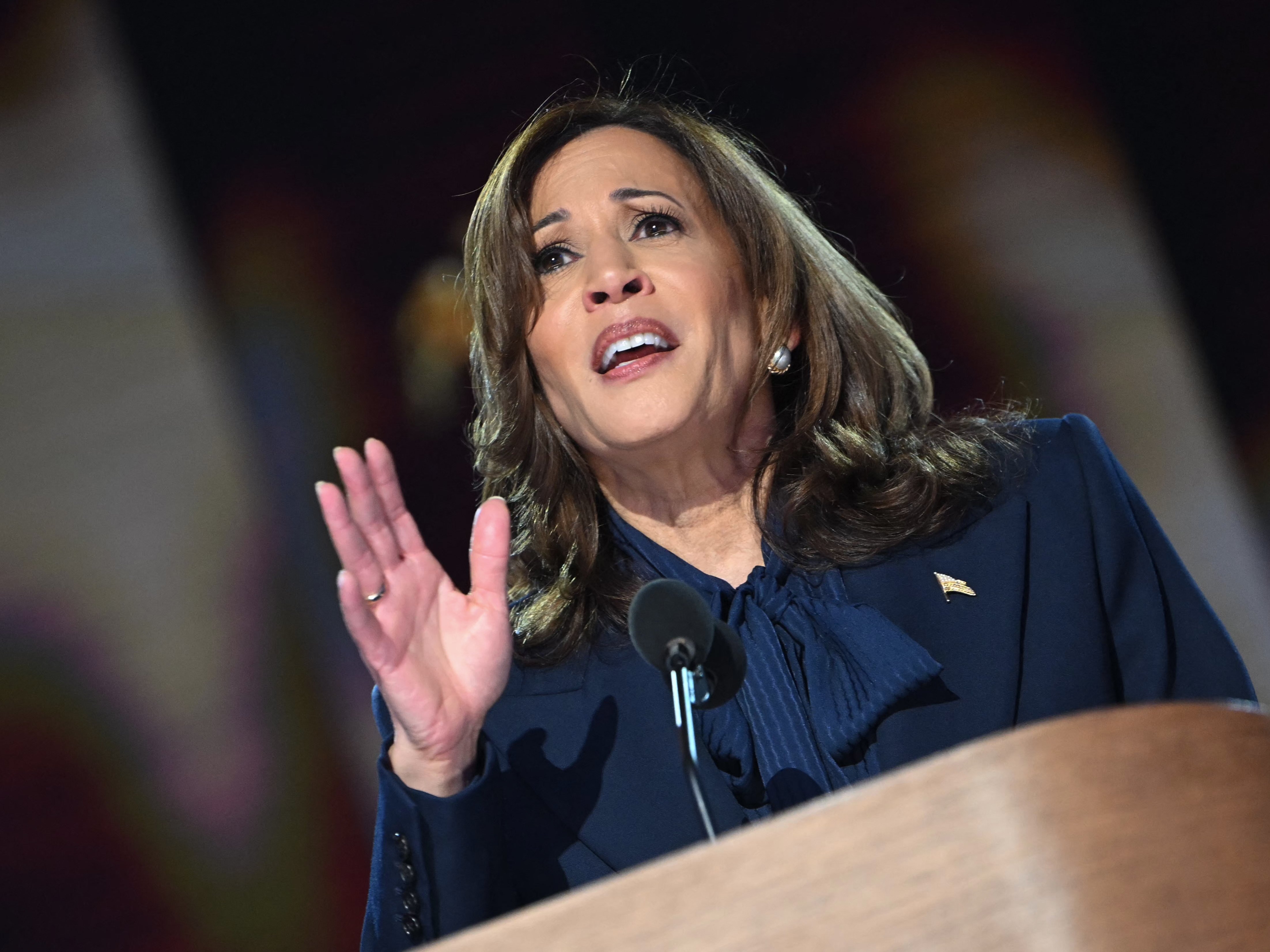 caption: Vice President and Democratic presidential candidate Kamala Harris waves as she arrives to speak on the fourth and last day of the Democratic National Convention at the United Center in Chicago, on Aug. 22.