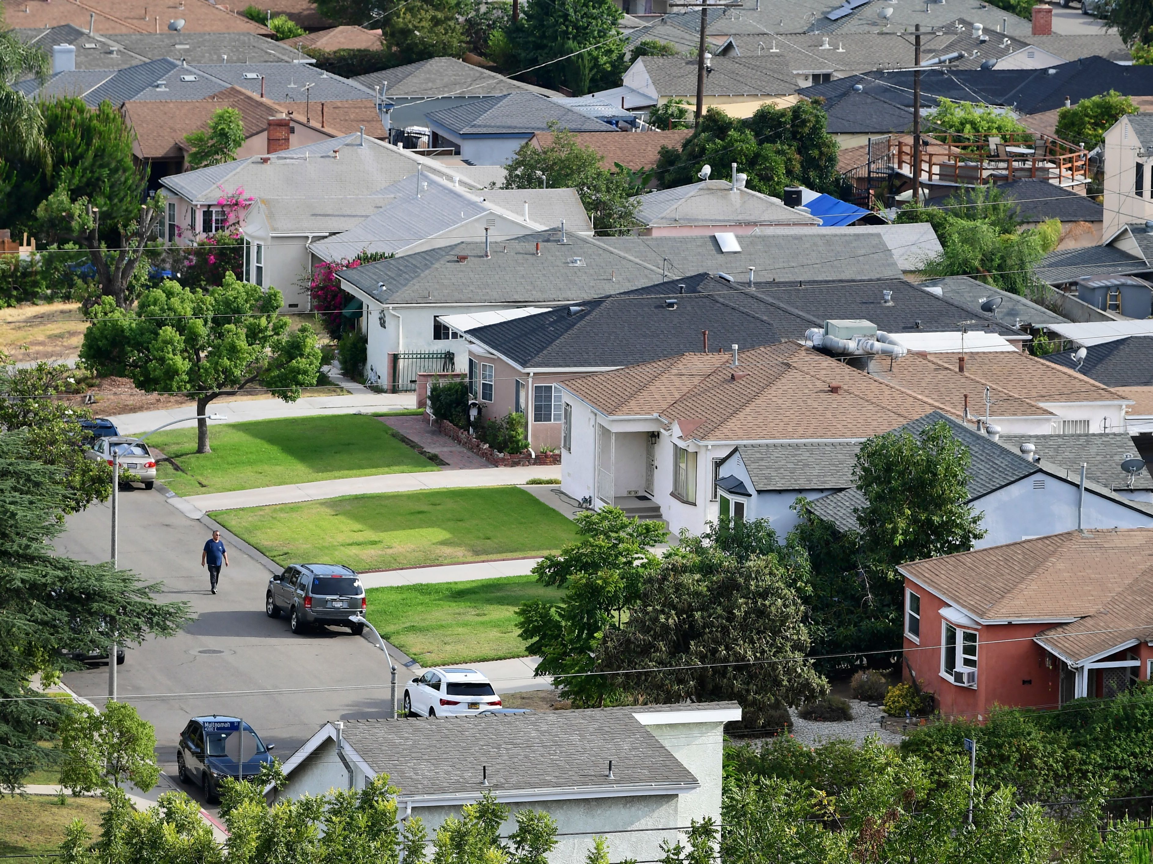 caption: A man walks through a neighborhood of single-family homes in Los Angeles last week. The CDC announced a new temporary eviction ban a few days after the previous one expired.