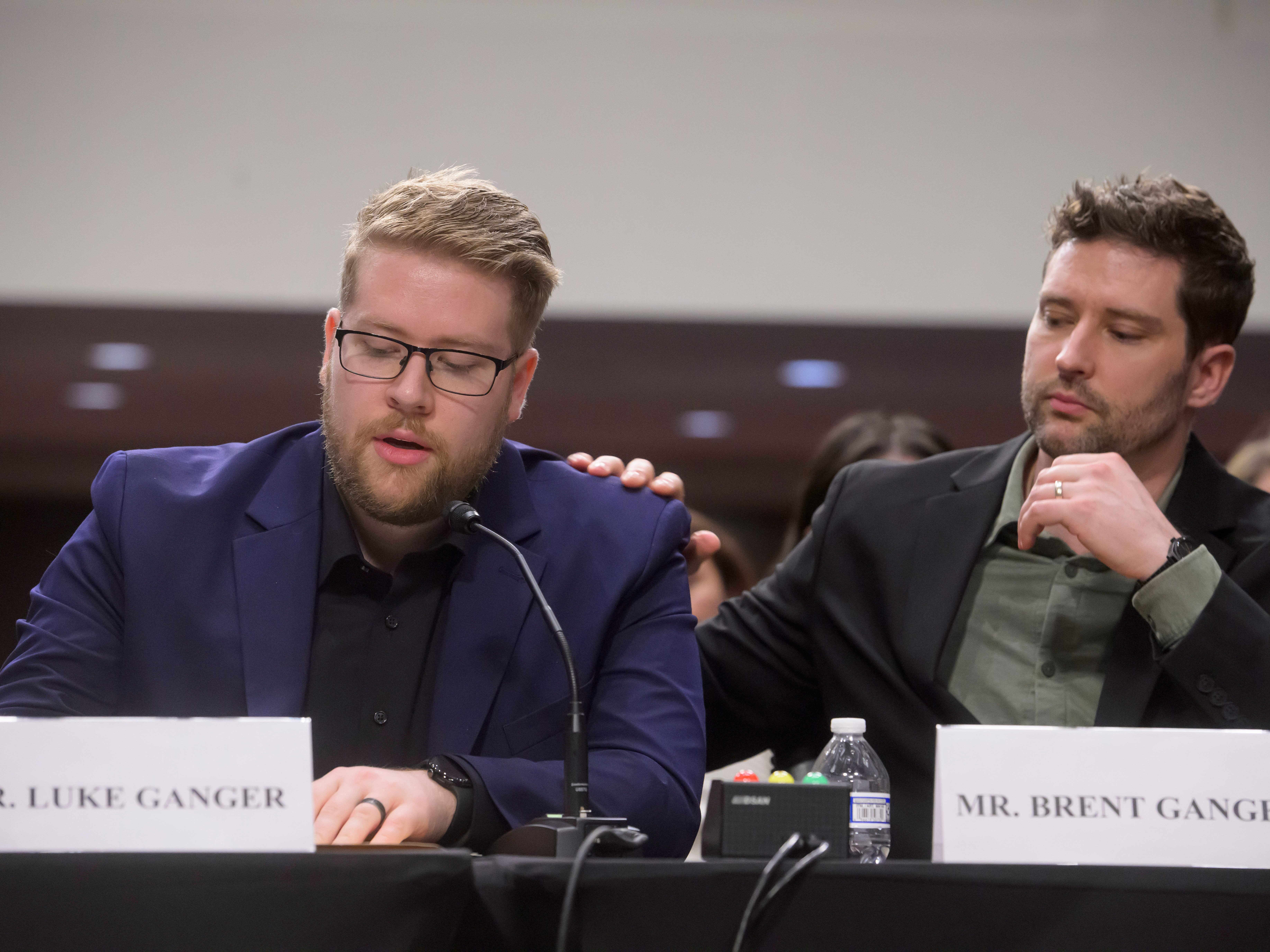 caption: Luke Ganger, left, and Brent Ganger, right, brothers of Renee Good, appear during a Bicameral Public Forum on the Disproportionate Use of Force by DHS Agents, on Capitol Hill, Tuesday, Feb. 3, 2026, in Washington.