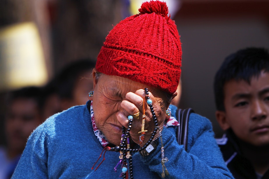 caption: Mother of Nepalese mountaineer Ang Kaji Sherpa, killed in an avalanche on Mount Everest, holds prayers beads in her hand and cries while she waits for his body at Sherpa Monastery in Katmandu, Nepal, on April 19, 2014. 