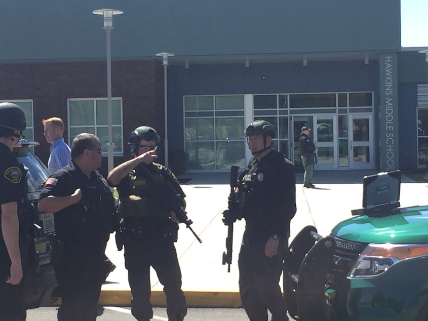 caption: Officers from multiple agencies clearing Hawkins Middle School after reports of a shooter.