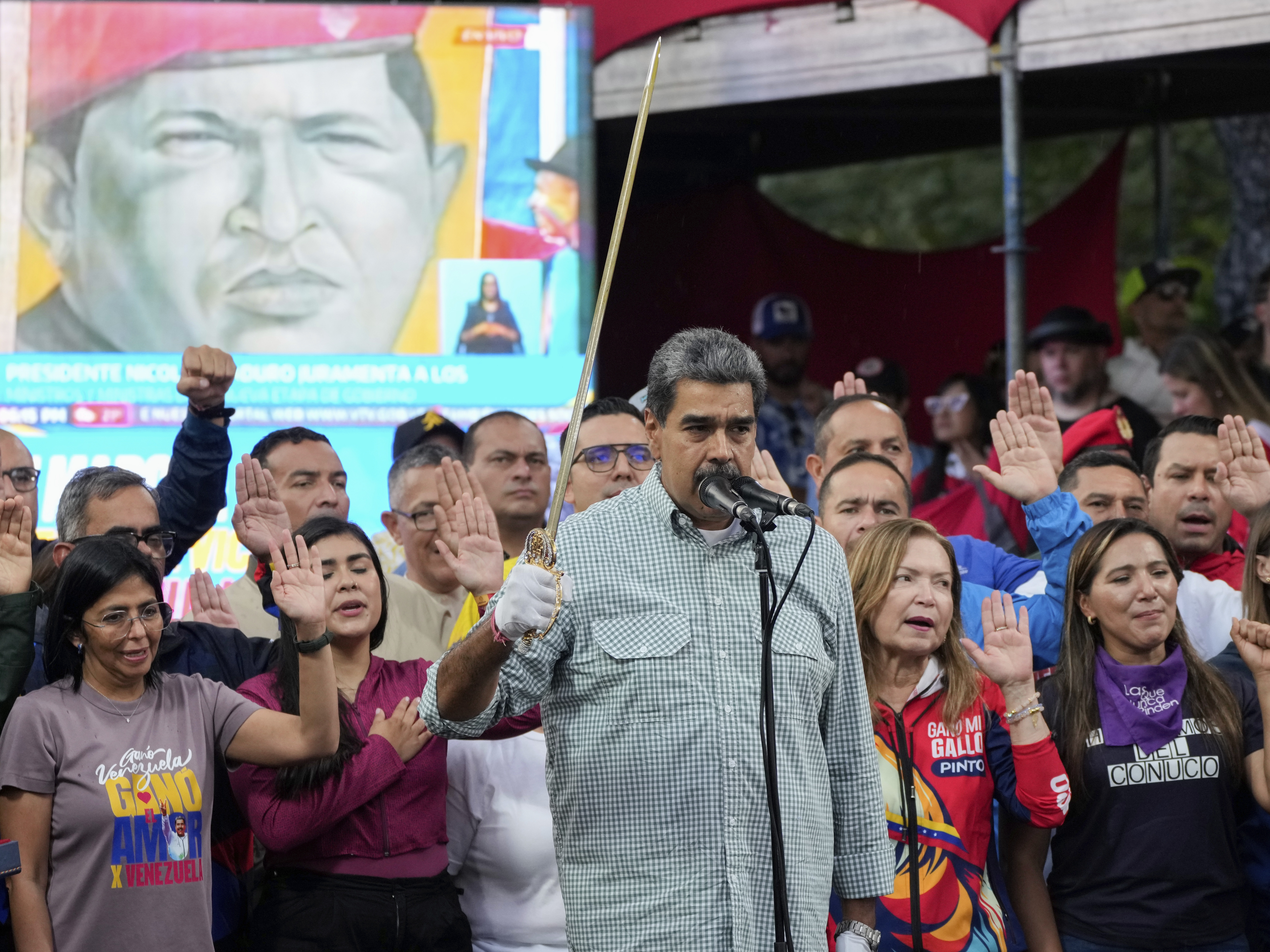 caption: Venezuelan President Nicolás Maduro brandishes a sword as his new Cabinet takes the oath of office, at the presidential palace in Caracas, Venezuela, Aug. 28.
