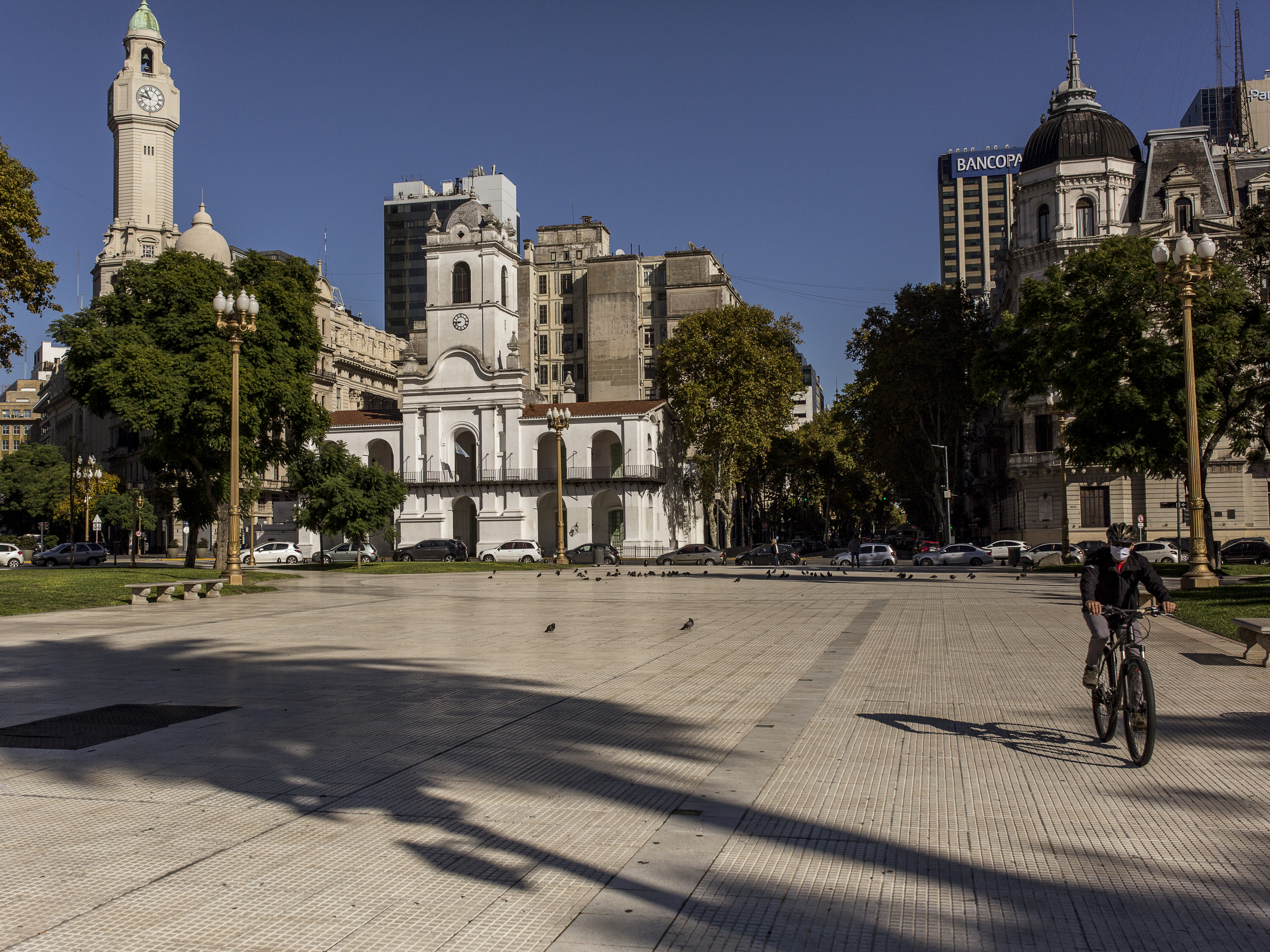 caption: A cyclist crosses Plaza de Mayo in the center of Buenos Aires on April 30. Argentina is loosening its strict lockdown but keeping most restrictions in the capital in place.
