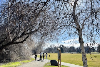 caption:  People walk along a trail at Leslie Groves Park in Richland, Wash.