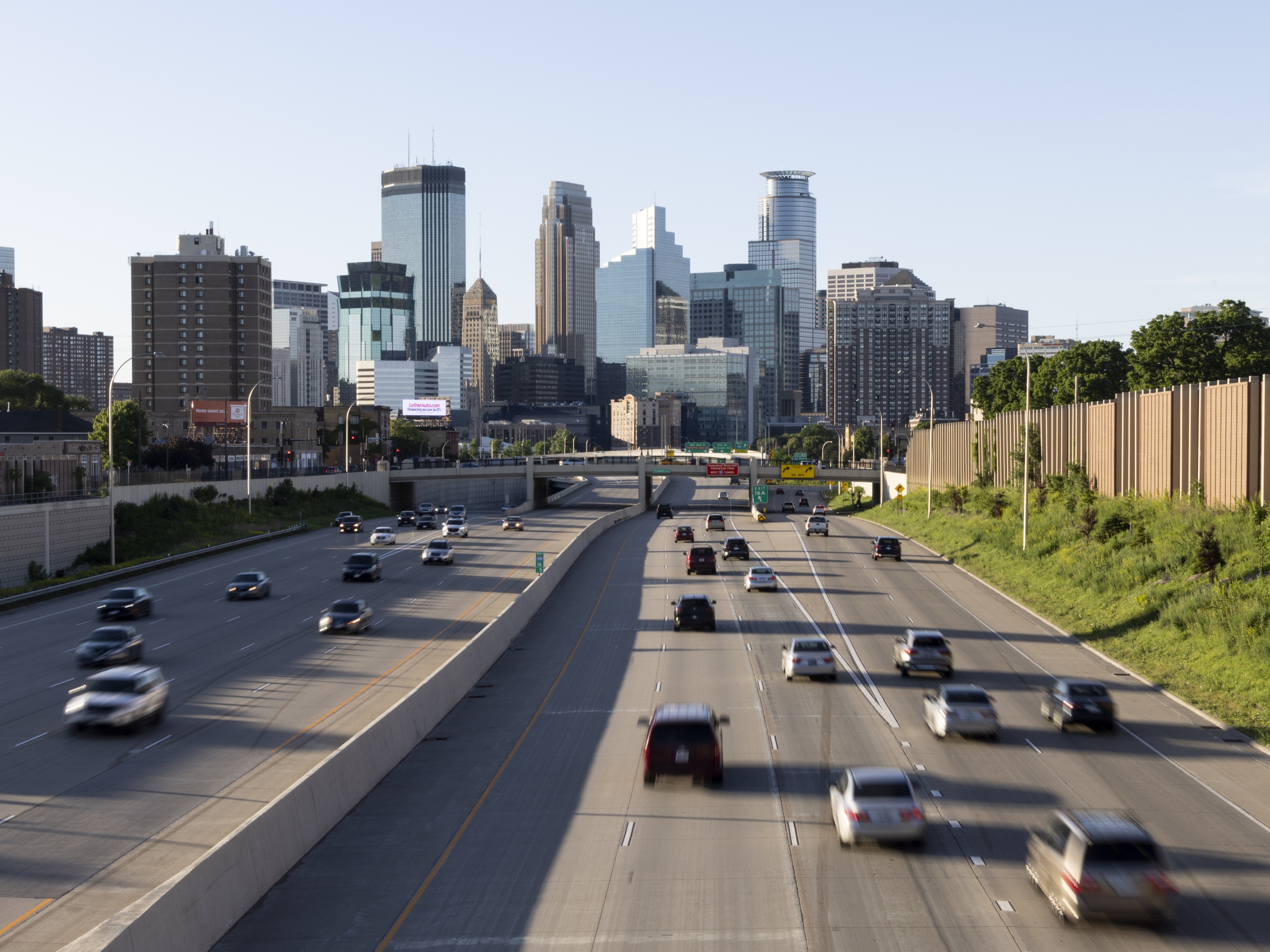 caption: Vehicles drive toward downtown Minneapolis on Interstate 35 on a Sunday in May.