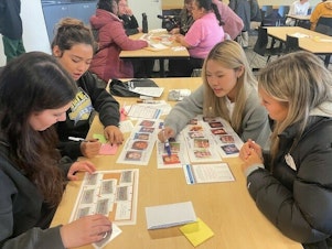 caption: High school students taking part in the University of Washington's annual MisInfo Day in March 2024 They are looking at pictures of faces to tell whether the images were created with generative AI tools or authentic.