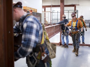 caption: In 2018, Garret Morgan (center) was training as an ironworker near Seattle. Five years later, he says he made the right career choice: "I'm loving it every day."