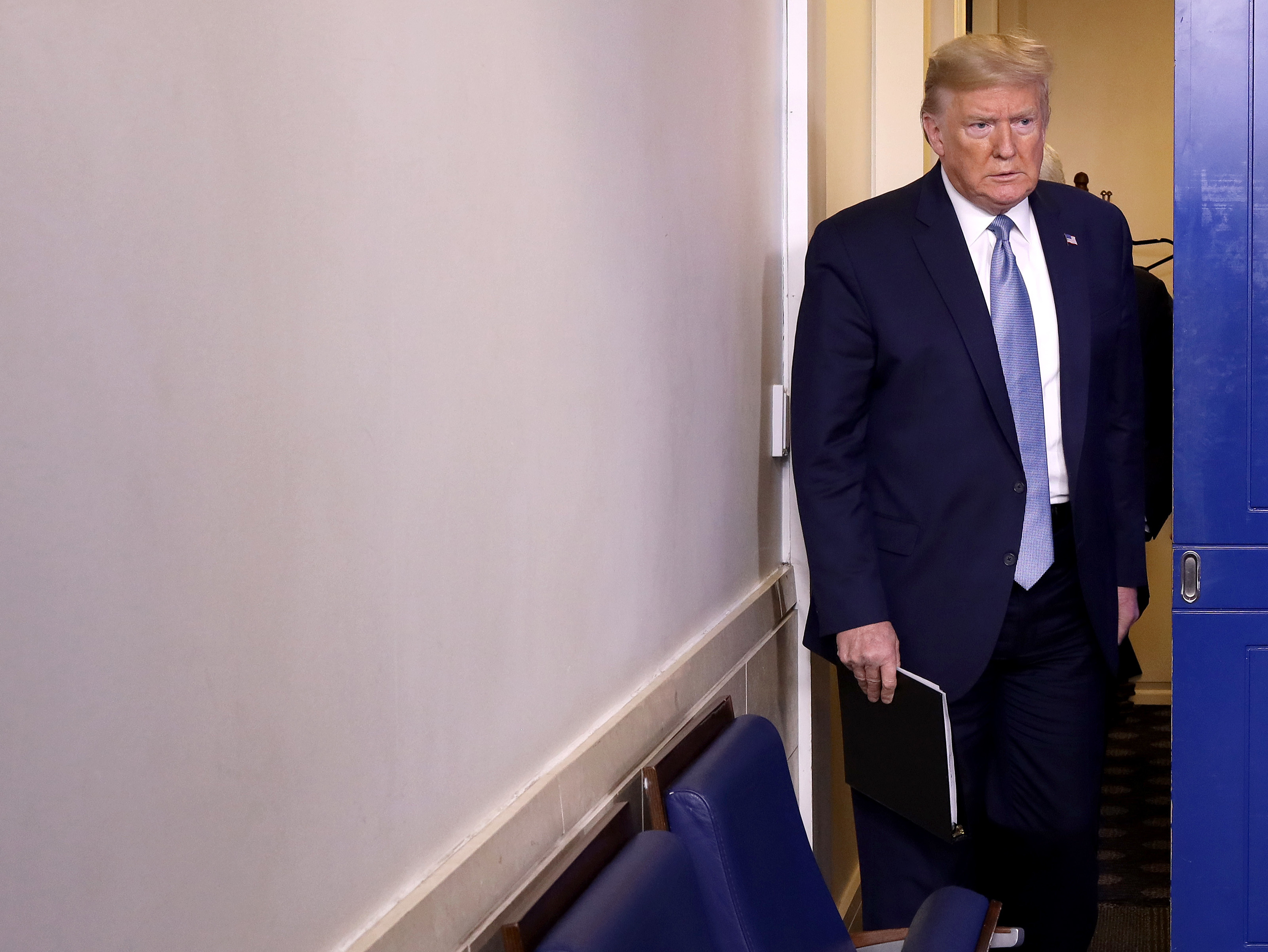 caption: President Trump arrives in the press briefing room to speak about the coronavirus at the White House on Monday.