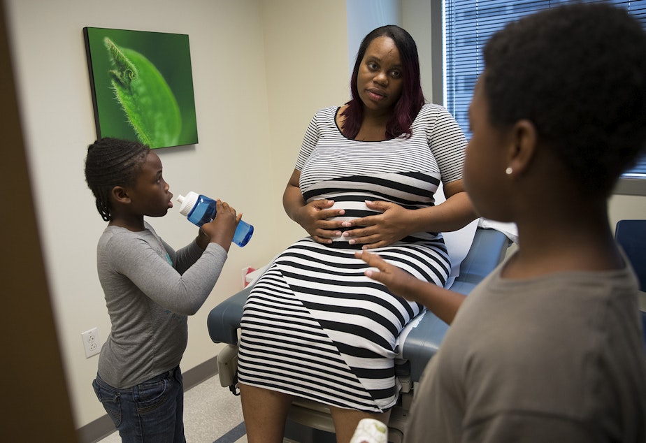 caption: Tiffany Hicks, center, with her kids Mariah, left, and Matthew, right, during a doctor's appointment on Monday, August 14, 2017, at Swedish OB/GYN Specialists on Madison St., in Seattle.