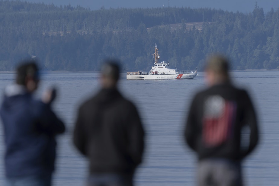 caption: A U.S. Coast Guard vessel searches the area, Monday, Sept. 5, 2022, near Freeland, Wash., on Whidbey Island north of Seattle where a chartered floatplane crashed the day before. The plane was en route from Friday Harbor, Wash., to Renton, Wash. 