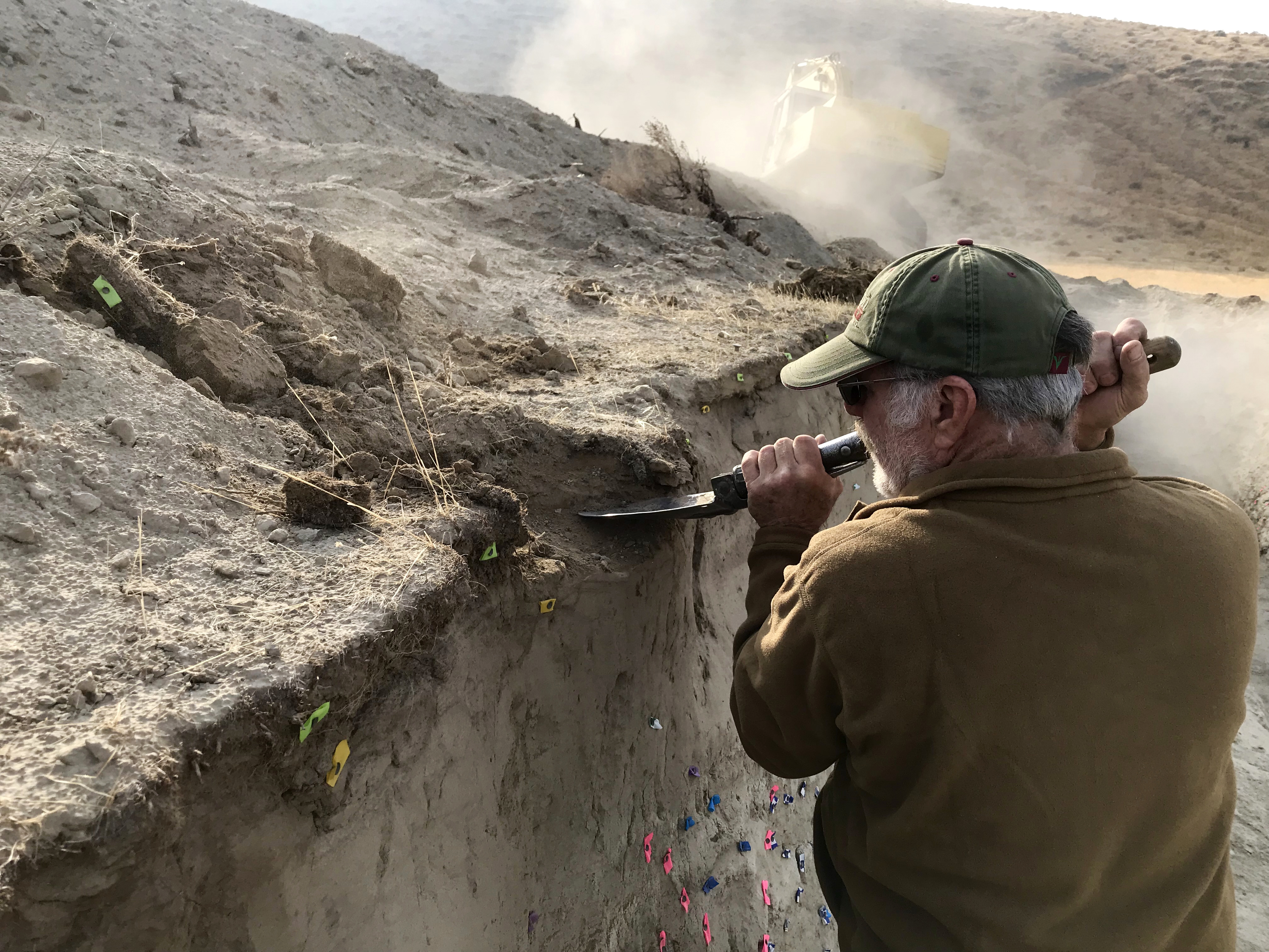 caption: USGS volunteer John Lasher helps dig volcanic ash out of the trench in this dig area southeast of Pasco. 