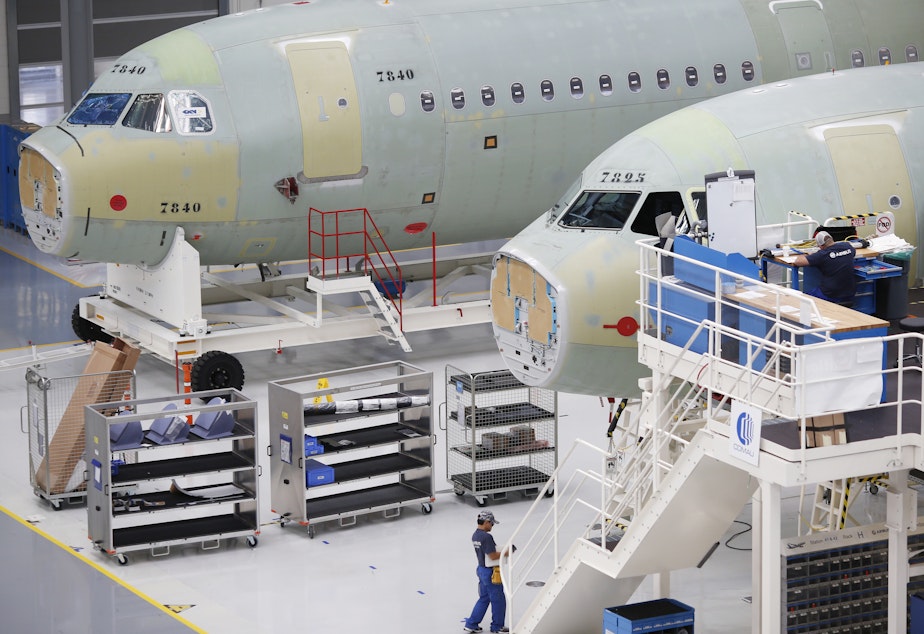 caption: Employees work on Airbus SE A321 fuselages at the company's final assembly line facility in Mobile, Ala. in 2017.