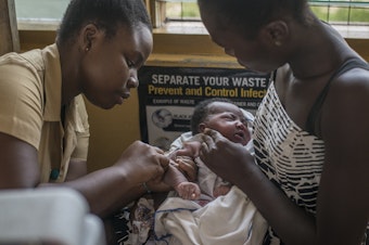 caption: A nurse administers the world's first malaria vaccine during a 2019 pilot program in Ghana. The World Health Organization has now recommended the vaccine for use in countries with moderate to high levels of malaria transmission.
