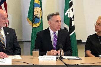 caption: Former Seattle Mayor Tim Burgess, King County Executive Dow Constantine and Deputy Executive Rhonda Berry at a press conference announcing the intent to move youth detention oversight to Public Health Seattle King County.