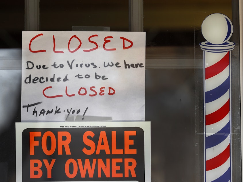 caption: Signs are displayed in the window of a store in Grosse Pointe Woods, Mich. The Paycheck Protection Program, aimed at helping small businesses survive the coronavirus crisis, has been beset by problems.