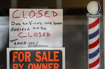 caption: Signs are displayed in the window of a store in Grosse Pointe Woods, Mich. The Paycheck Protection Program, aimed at helping small businesses survive the coronavirus crisis, has been beset by problems.