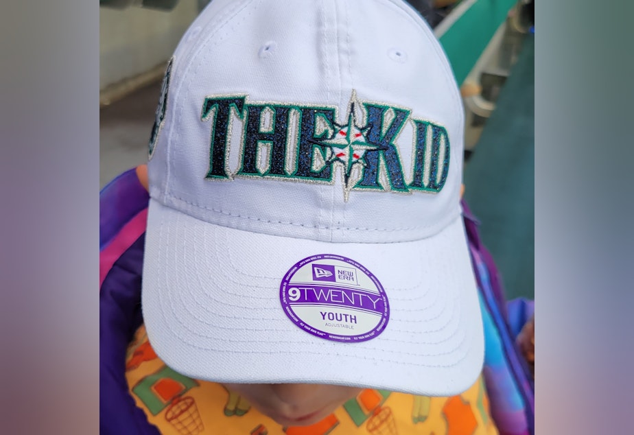 caption: Our 9 year old guide to the ballpark, Edmund Bollay, shows off his new hat...