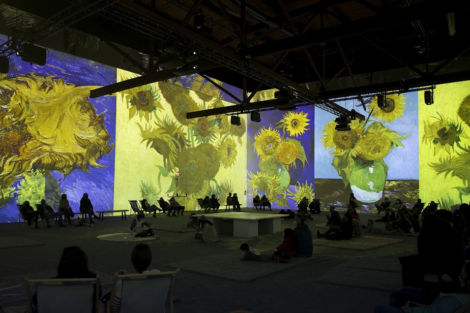 caption: Patrons take in various projections of Van Gogh's work in the 360-degree 8,000 square foot immersive room at the exhibit on Wednesday, October 27, 2021, along Occidental Avenue in Seattle. 