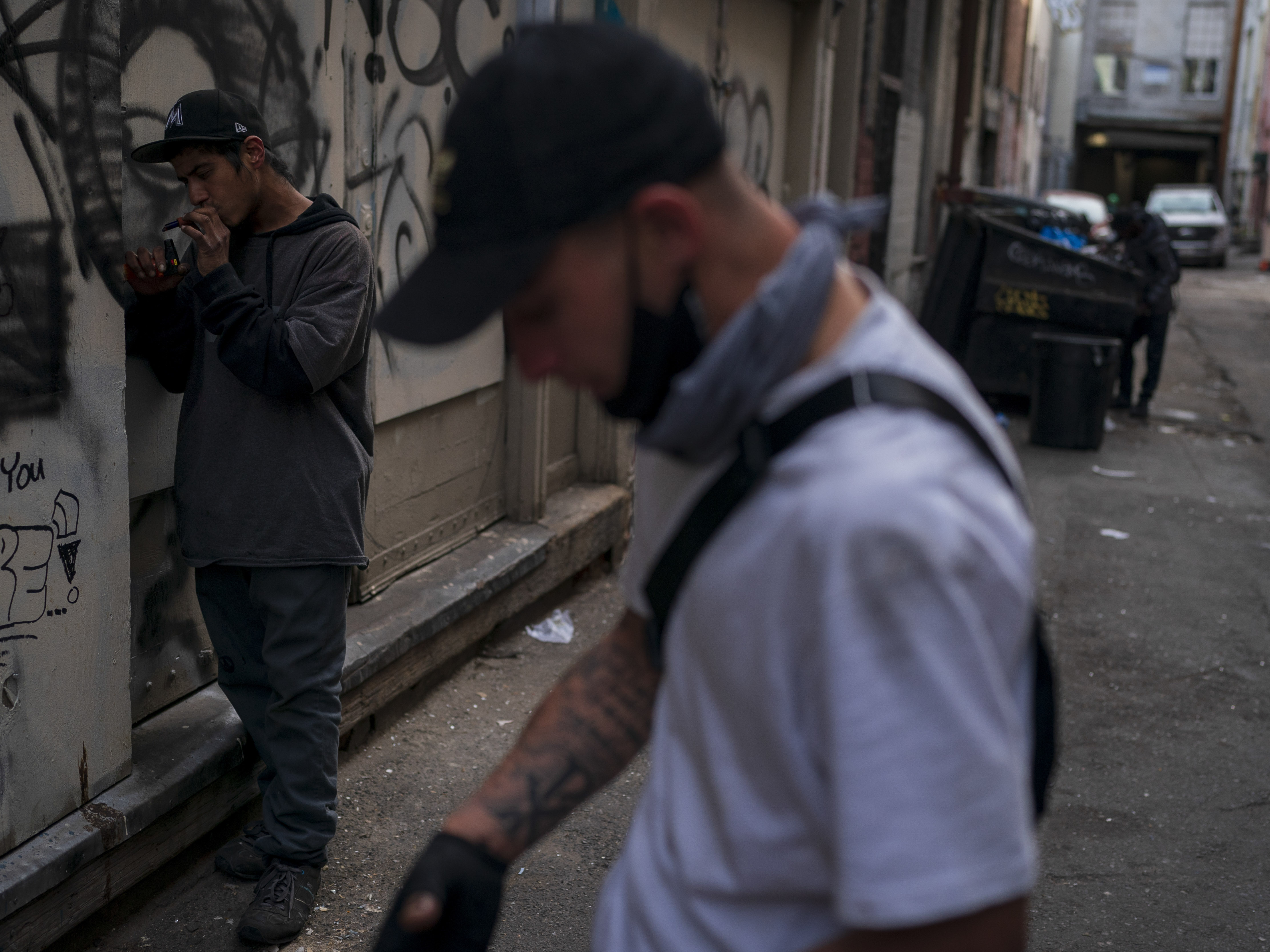 caption: Two men smoke fentanyl in an alley in Los Angeles on April 18, 2022. The latest federal data show more than 109,000 drug deaths in 2022, many from fentanyl.