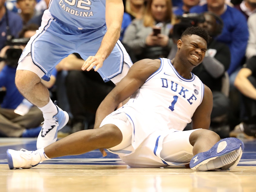 caption: Duke's Zion Williamson reacts after falling as his shoe breaks in the game against the North Carolina Tar Heels Wednesday in Durham, N.C.