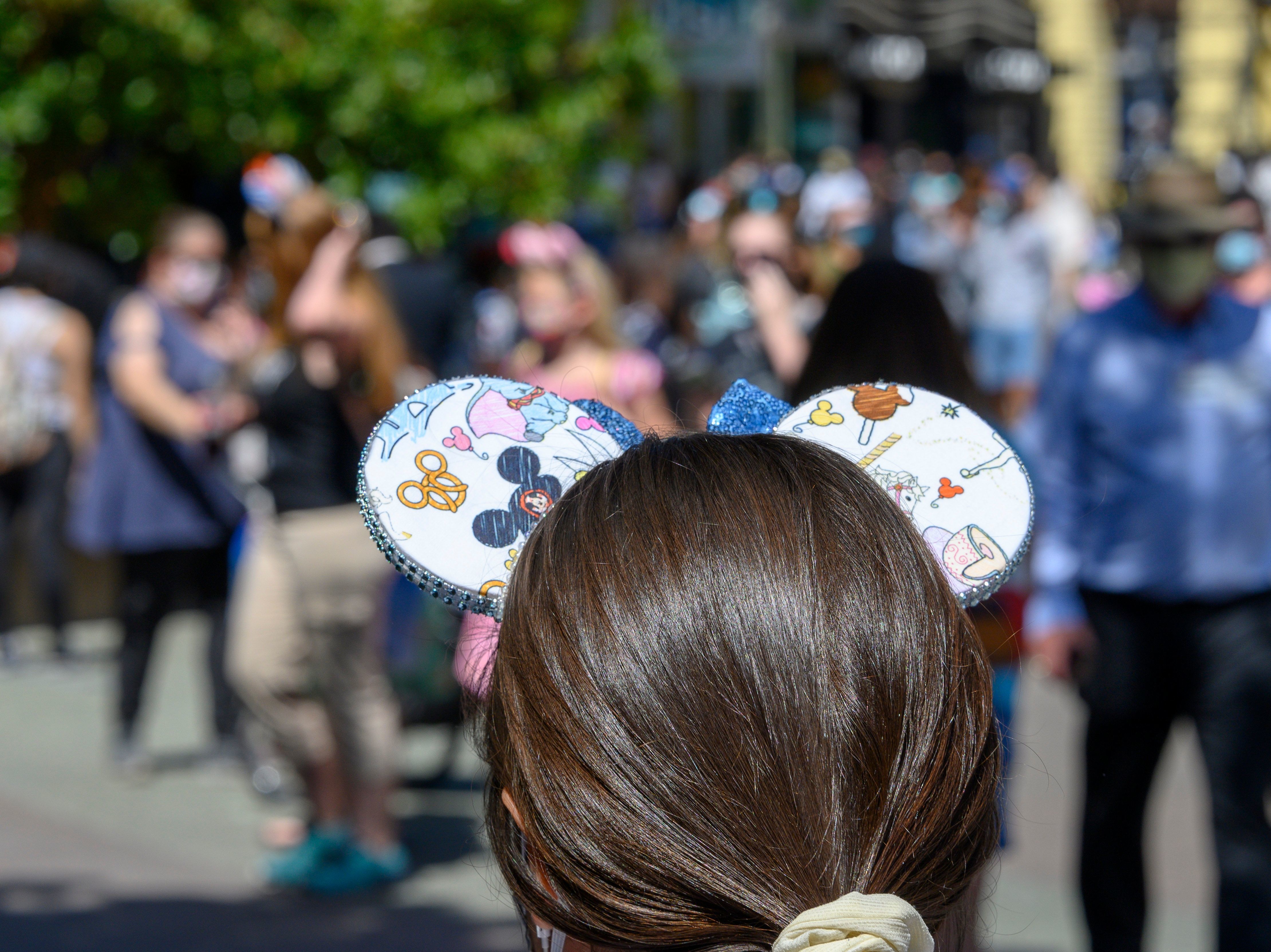 caption: People visit Downtown Disney in Anaheim, California on July 9, 2020, the first day the outdoor shopping and dining complex was open to the public since closing in March amid the onset of the COVID-19 pandemic.