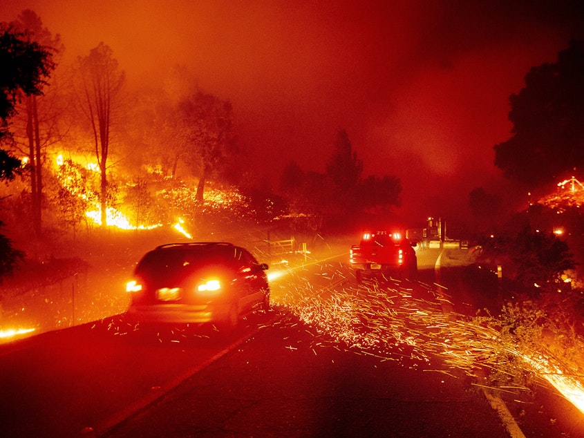 caption: Embers fly across a roadway as the Kincade Fire burns through the Jimtown community of Sonoma County, Calif., on Thursday, Oct. 24, 2019. 