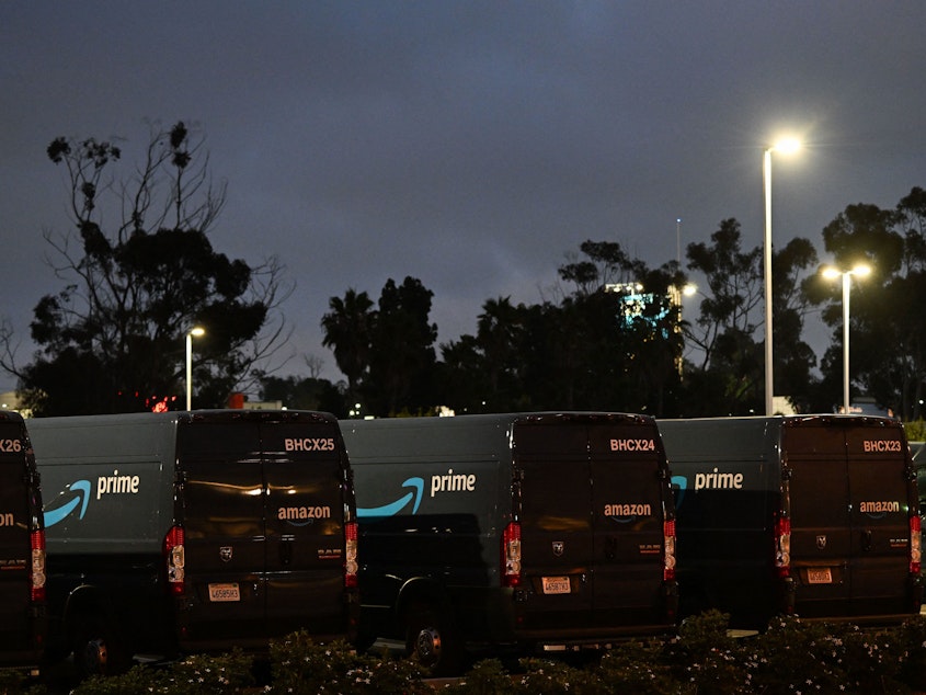 caption: Delivery vans marked with the Amazon Prime logo are seen parked outside a delivery facility in Culver City, Calif., in 2022.