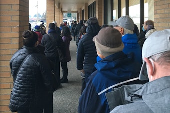 caption: People line up outside the Sea Mar clinic in Federal Way, January 21, 2021. The clinic is offering vaccine doses on a walk-in basis, subject to availability. 