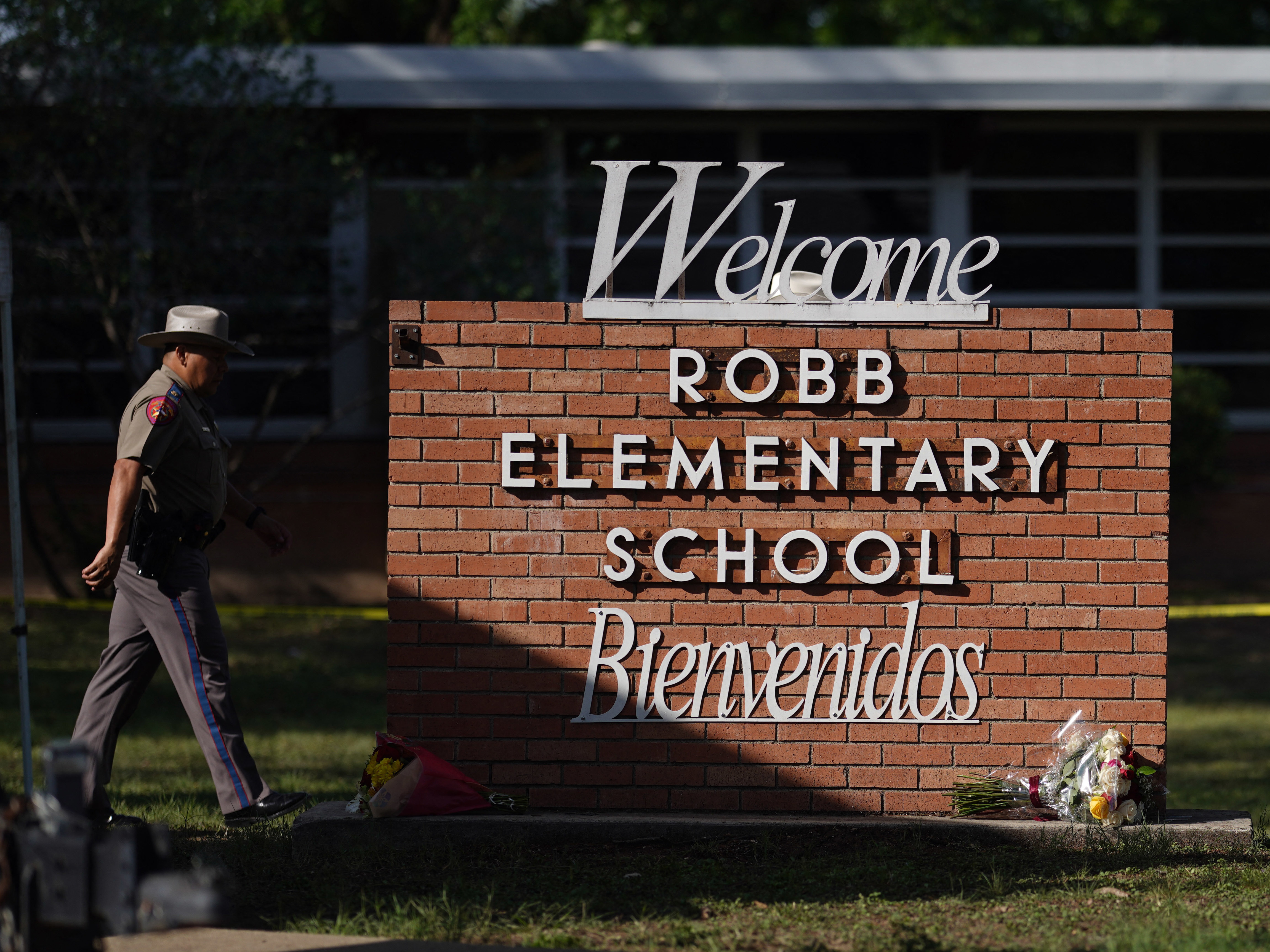 caption: An officer walks outside of Robb Elementary School in Uvalde, Texas, on May 25.