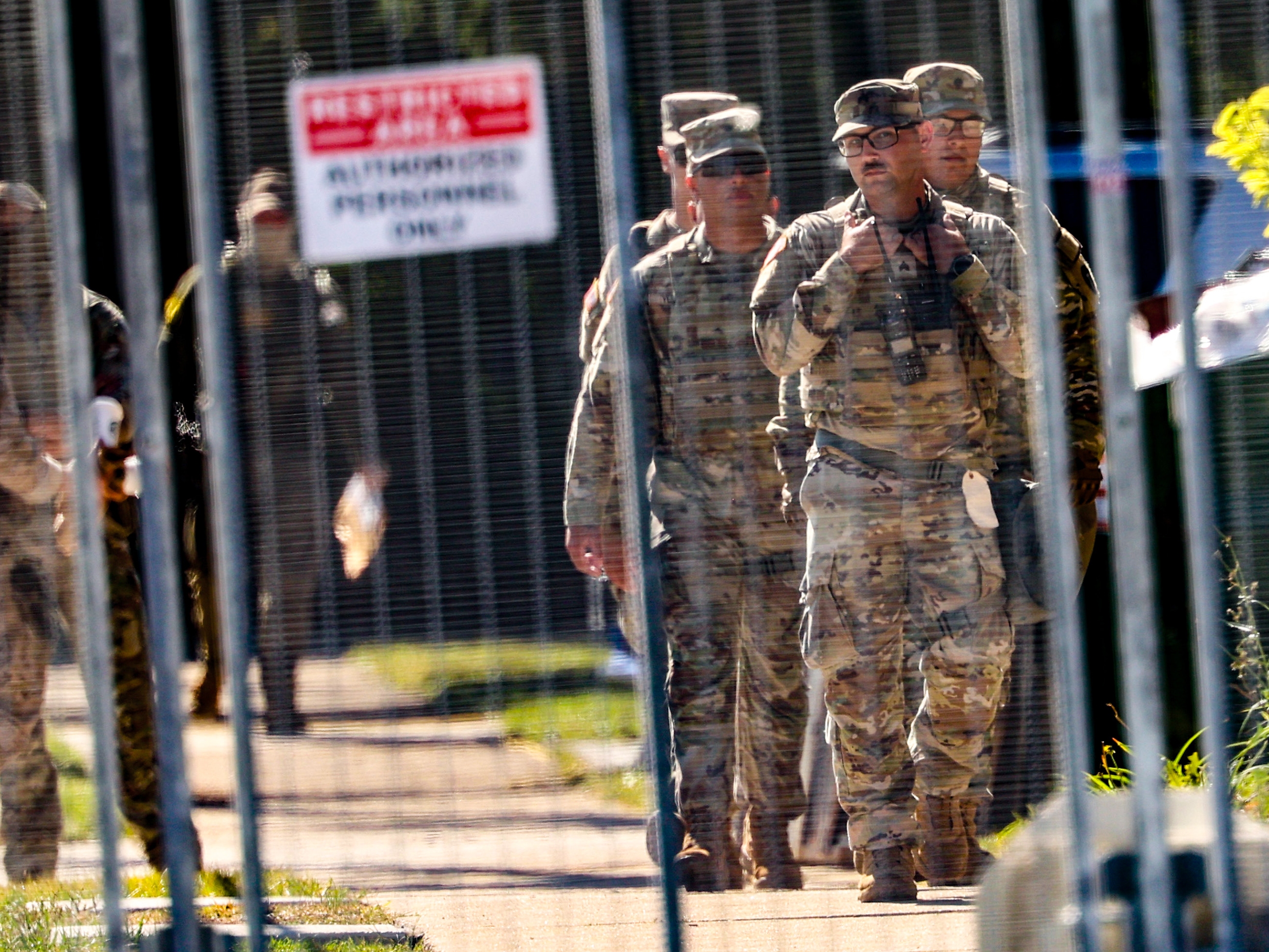 caption: National Guard members walk around outside the U.S. Immigration and Customs Enforcement holding facility in Broadview, Ill., on Oct. 9.